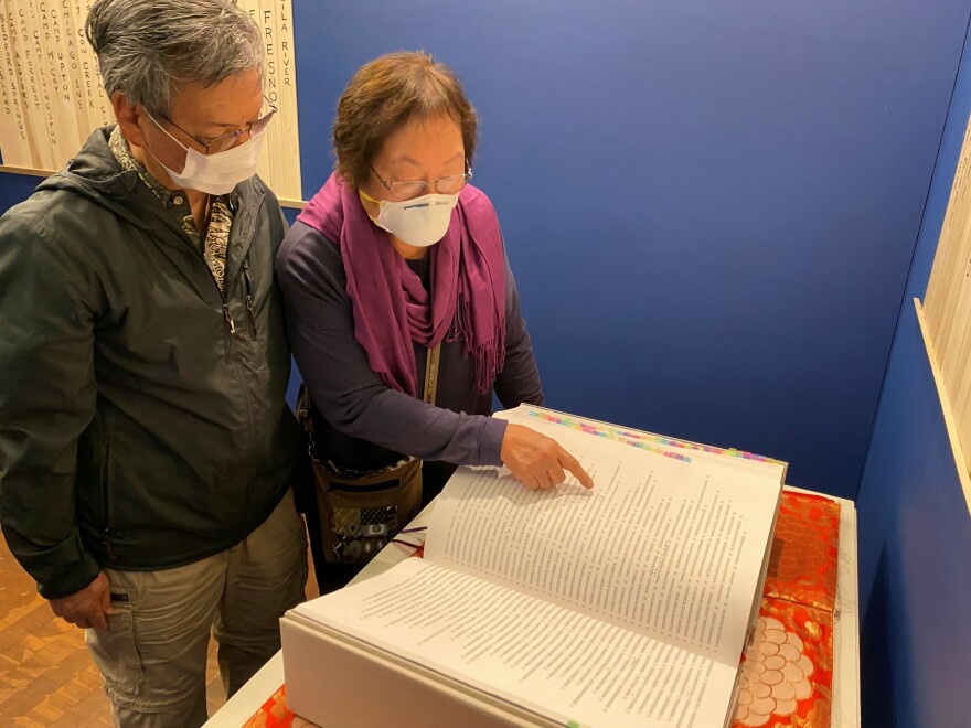 Frances and Ford Kuramoto visiting the Ireichō at the Japanese American National Museum in Los Angeles. The book collects the names of those interned at camps during the war.