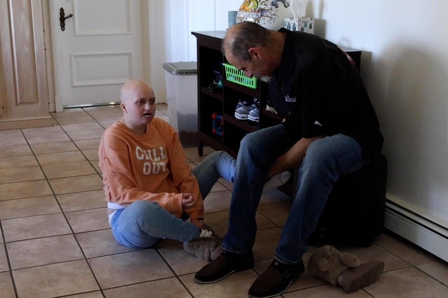 Rob Wilson helps his daughter Olivia put her shoes on.