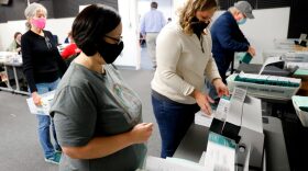 Workers start pre-processing absentee ballots at the city of Lansing Clerk's Election Unit in Lansing, Michigan.