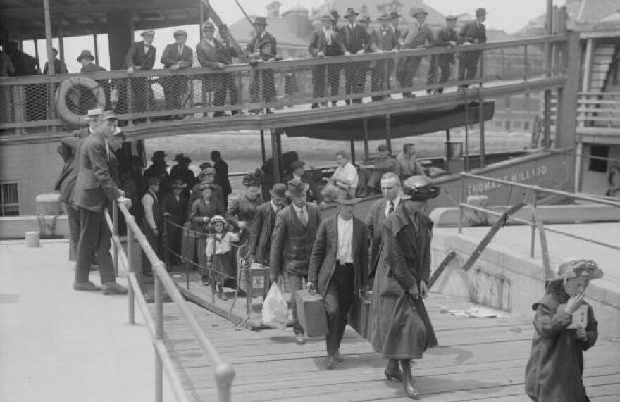 Immigrants arrive at Ellis Island in Upper New York Bay around 1900. In 1924, the U.S. would restrict immigration based on national origin. Forty years after that, it eliminated those restrictions.