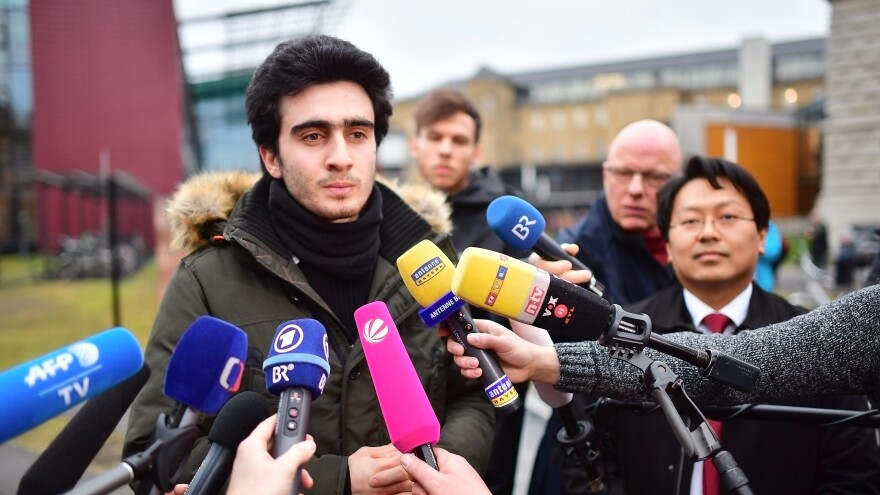 Anas Modamani speaks to the media Feb. 6 in Wuerzburg, Germany, after a court session about his lawsuit against Facebook. Modamani's suit, regarding the misuse of a selfie he took of himself with German Chancellor Angela Merkel was rejected, but his lawyer Lawyer Chan-Jo Jun, right, says that under a new law a lawsuit might not even have been necessary.