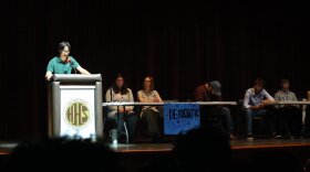 Student speaking at a podium during a mock presidential debate