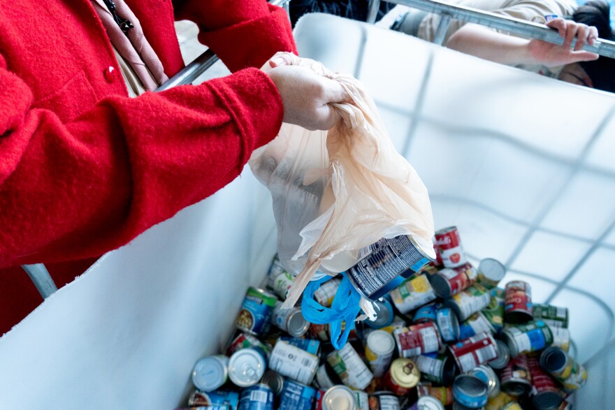 Canned goods are dumped into a sorting bin that is filled with donated food at the local fire station in Clayton, Mo.