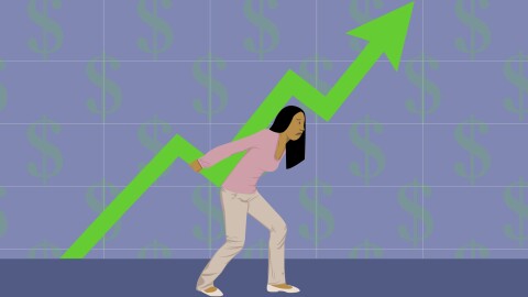 A cartoon woman wearing tan pants and a pink shirt frowns. She's walking and holding up a bright green arrow with her back. The arrow is similar to one found on a graph. There is a grid and opaque dollar signs set against a blue background. 