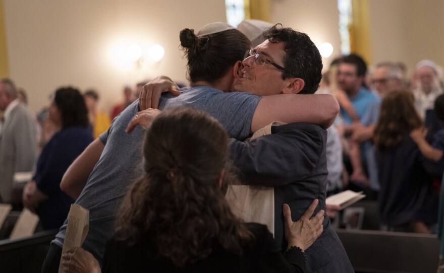 Rabbi Justin Kerber hugs congregant Sam Karoll during the temple's deconsecration ceremony on May 18, 2019.
