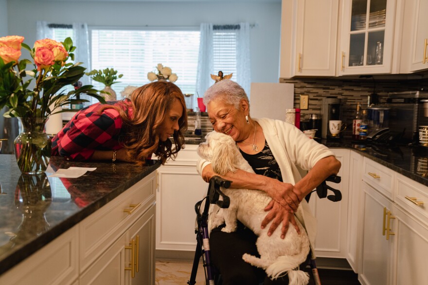 Tyrone Ferrens' wife, Michelle Ferrens, and his mother, Patricia Villa, talk to their dog Ashe.