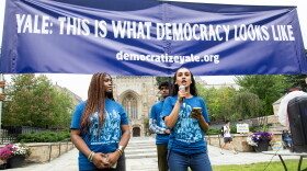 Students with Democratize Yale speak in front of the university's Sterling Memorial Library.