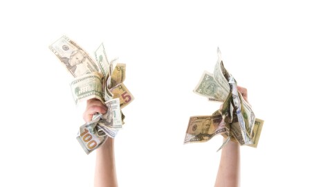 two hands hold lots of cash in the air