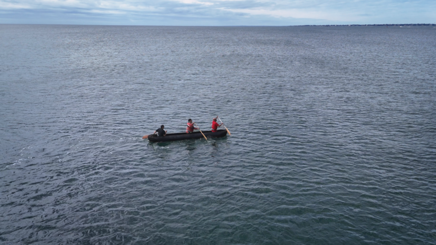 Jonathan James-Perry and crew paddle the mishoon in the Sakonnet