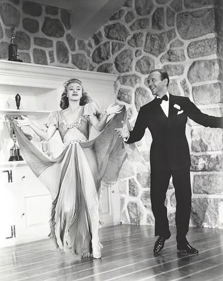 Black and white photo of man and woman dancing side by side 