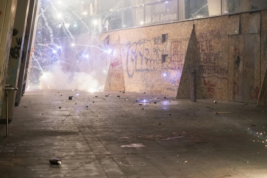 Fireworks go off outside the boarded up federal courthouse during 4th of July demonstrations against systemic racism and police violence in Portland, Ore.
