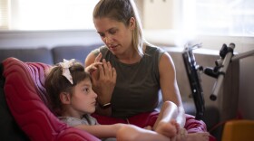 Jenny Eckart Hoyt directs her daughter Winnie's attention to an "eye gaze" device in their Portland, Ore., home. The communication skills the eye gaze can unlock are critical for Winnie's educational future. To master it, Winnie needs a lot of practice with a trained instructor.
