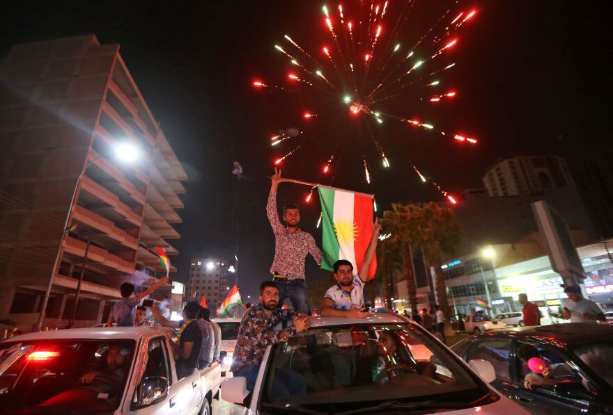 Iraqi Kurds wave the Kurdish flag as they celebrate in the streets of the northern city of Irbil on Monday following a referendum on independence.
