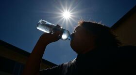 A child sips water from a bottle under a scorching sun on Tuesday in Los Angeles. Forecasters say temperatures  could reach as high as 112 degrees in the densely populated Los Angeles suburbs in the next week as a heat dome settles in over parts of California, Nevada and Arizona.