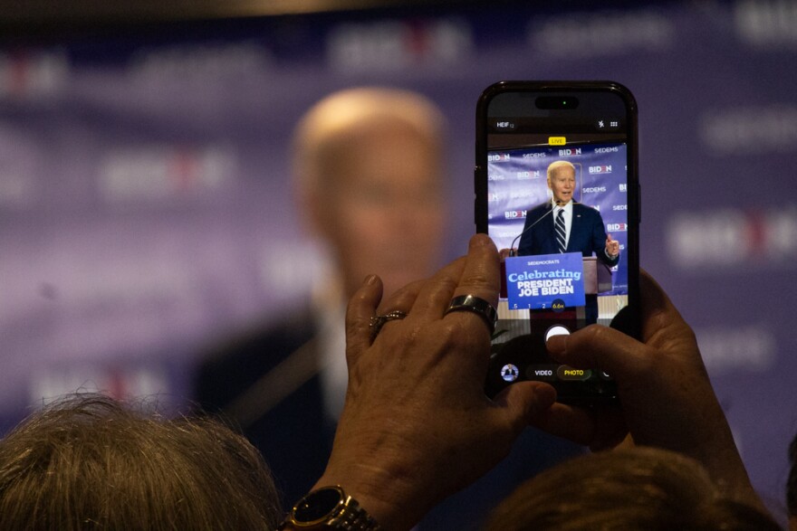 An onlooker takes a photo of Joe Biden as he speaks in Columbia Friday, Feb. 27.