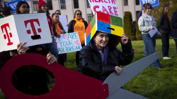 Emma LeFever, with Washington CAN, smiles before a group photo is taken following a rally against tax cuts for corporations on Thursday, February 26, 2026, at the Washington State Capitol campus in Olympia. KUOW Photo/Megan Farmer