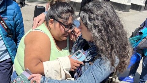 Miriam DeBadt, the youngest daughter of Dolores Bustamante, is comforted by immigrant advocate Carly Fox outside ICE offices in Buffalo after agents detained Bustamante on Wednesday, April 22, 2026.