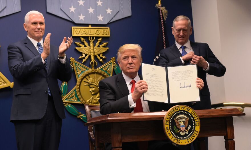 President Trump displays executive actions he has signed alongside Defense Secretary James Mattis and Vice President Pence on Friday at the Pentagon in Washington, D.C.