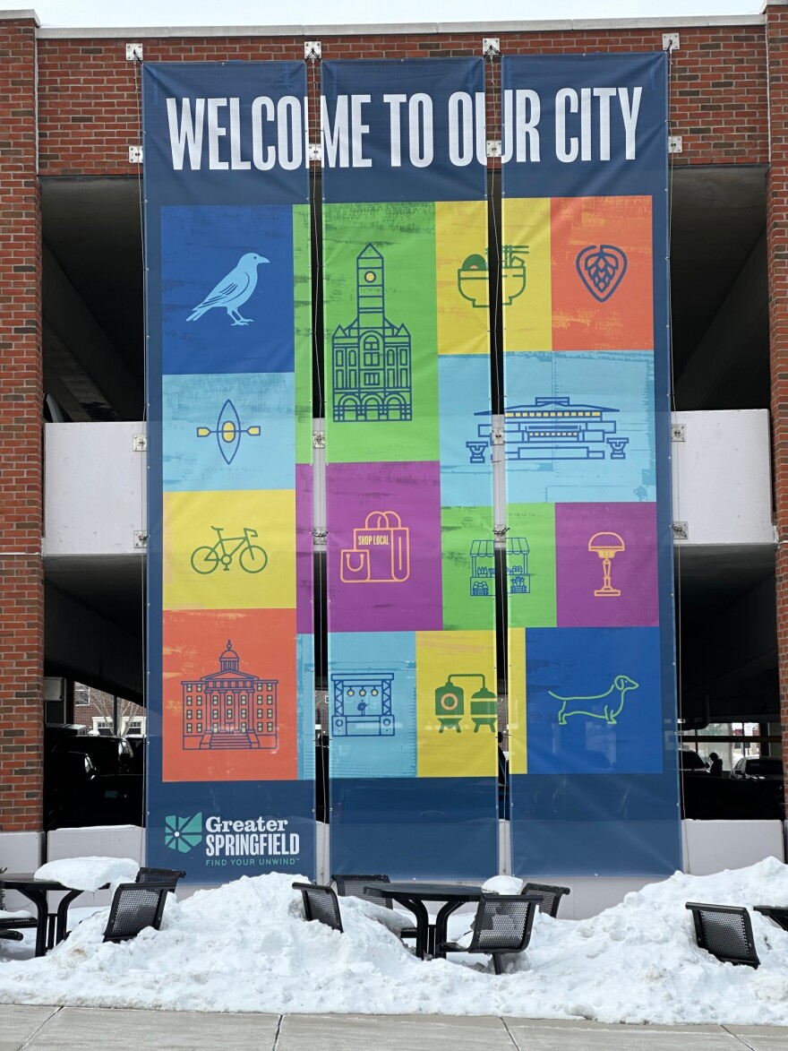 A "Welcome to our city" banner hangs from the side of a parking garage in downtown Springfield, Ohio.
