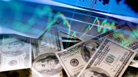 Dollar bills and stock market indicators. (Getty Images)
