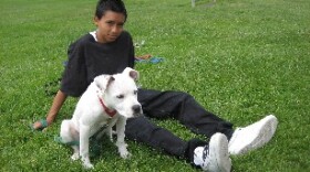 8th grader Alex Arzeta sits with his dog Fifi after a training session.