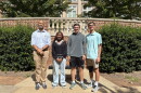 Civic Literacy Teacher Cristofer Wiley (left) stands with Reynolds High School students Tandy Adjei, Grant Cameron and Patrick Rais-Bahrami 