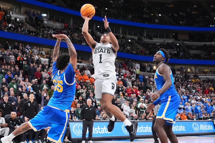 Michigan State guard Jeremy Fears Jr. (1) drives to the basket against UCLA guard Skyy Clark, left, and forward Eric Dailey Jr., right, during the second half of an NCAA college basketball game in the quarterfinals of the Big 10 Conference tournament, Friday, March 13, 2026, in Chicago. (AP Photo/Nam Y. Huh)