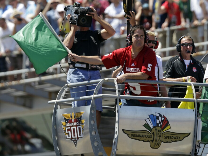 Dallas Mavericks owner Mark Cuban waves the green flag to start the 98th running of the Indianapolis 500 IndyCar auto race at the Indianapolis Motor Speedway in Indianapolis, Sunday, May 25, 2014. (AP Photo/Michael Conroy)