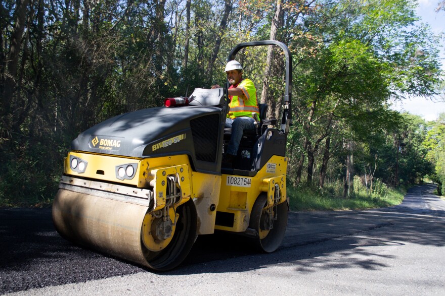Don Minnick operates a roller to compact and smooth the asphalt.