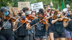 Protesters march at a violin vigil for Elijah McClain in Columbus, Ohio on July 4, 2020.