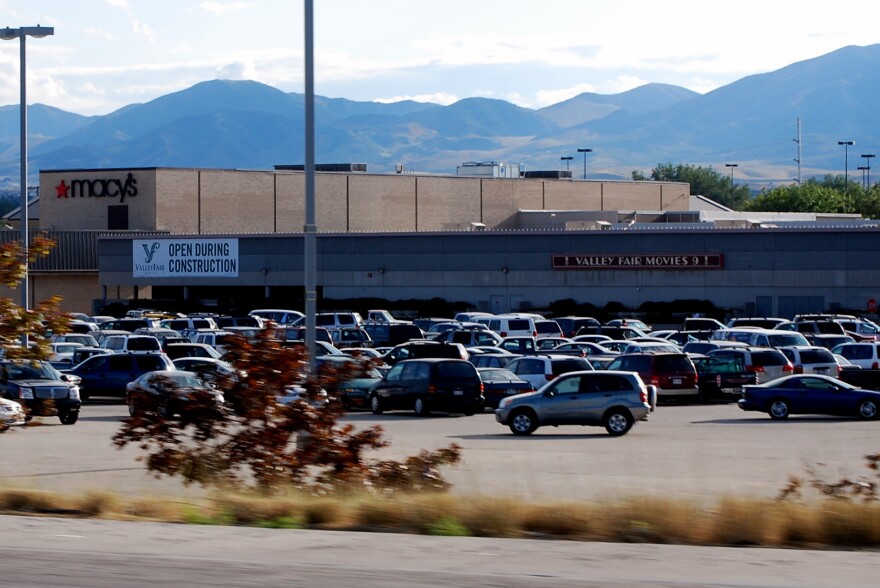 A parking lot full of cars next to a mall.