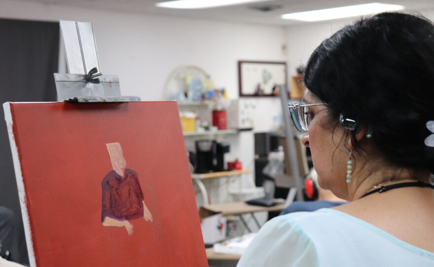 Vianey Morales examines her portrait during a June 24 session at the Art Center of Corpus Christi.
