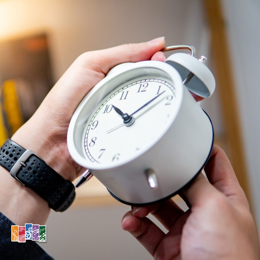 Male hand adjusting or changing the time on white clock. Time management concept.