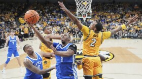 Kentucky's Lamont Butler (1) heads to the basket as teammate Brandon Garrison, left, watches as Missouri's Tamar Bates (2) defends during the second half of an NCAA college basketball game Saturday, March 8, 2025, in Columbia, Mo. (AP Photo/Jeff Roberson)