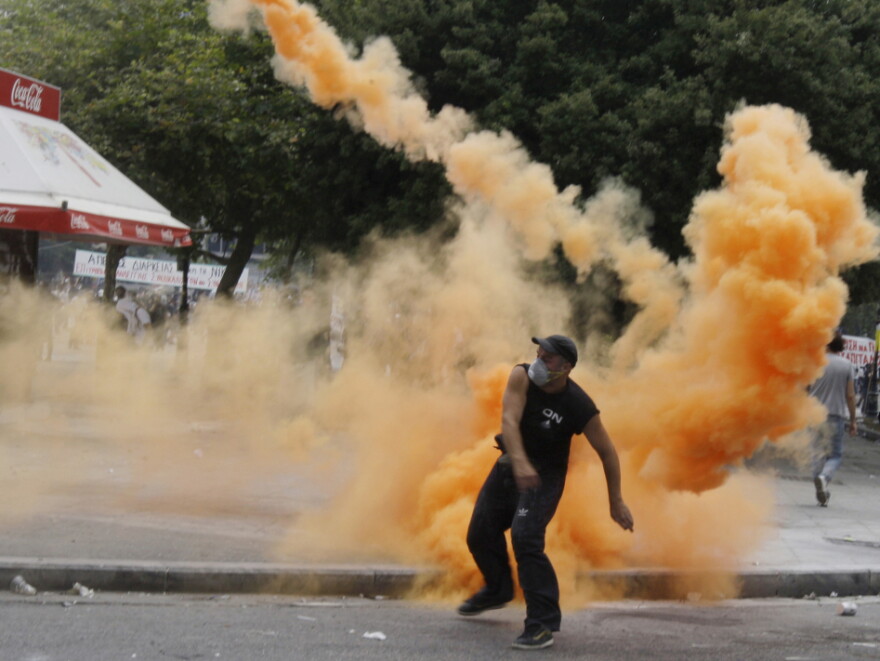 A protester throws a missile at riot police during clashes in central Athens on Wednesday during the Greek Austerity vote. Protests continue even after the Parliament voted for the bill.