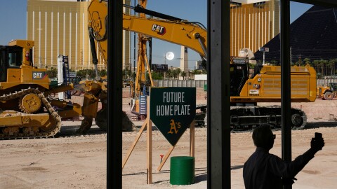 FILE - A person takes a picture near construction equipment during a groundbreaking ceremony for the Athletics' baseball stadium Monday, June 23, 2025, in Las Vegas. (AP Photo/John Locher, File)