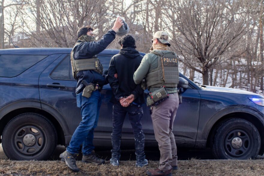 ICE agents search the passenger of a truck as they arrest both him and the driver during a traffic stop Wednesday, Feb. 11, 2026 on Bottineau Blvd. in Robbinsdale.