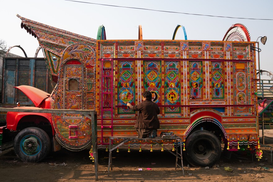 Painter Irfan Mohammad works on a truck at a sprawling workshop in Rawalpindi, Pakistan.