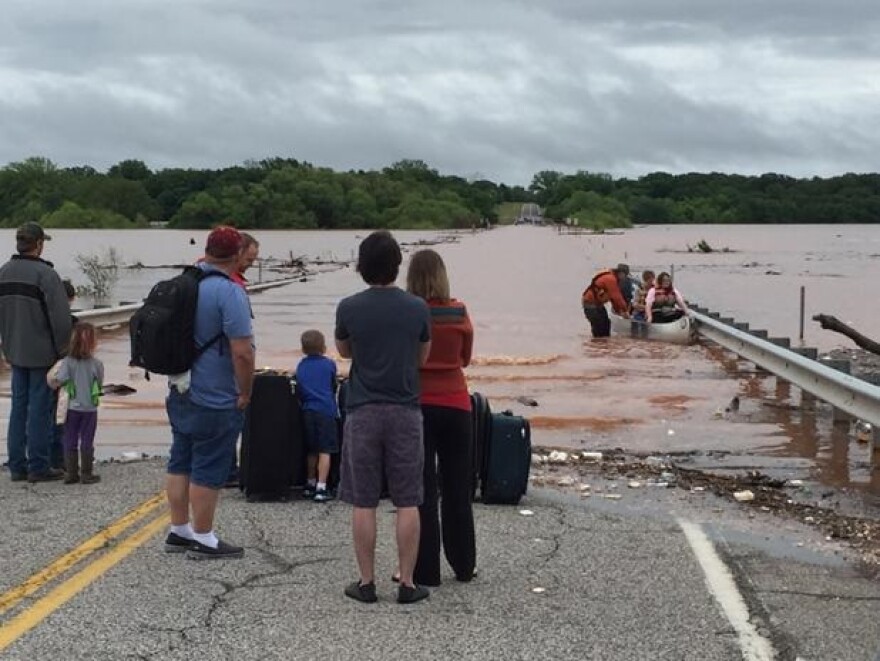 Residents being ferried away from east side of Lake Thunderbird by canoe.