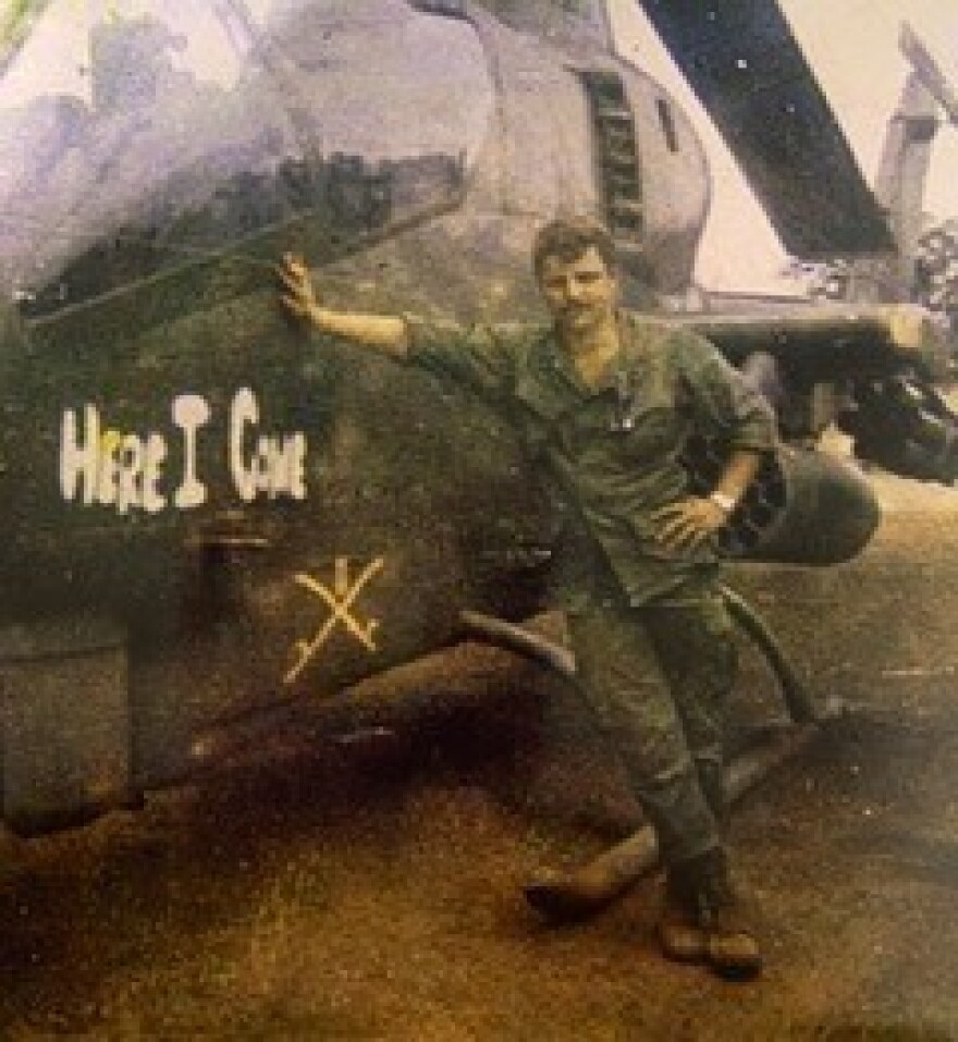 Veteran Harry Stapleton next to a helicopter in the Vietnam War.