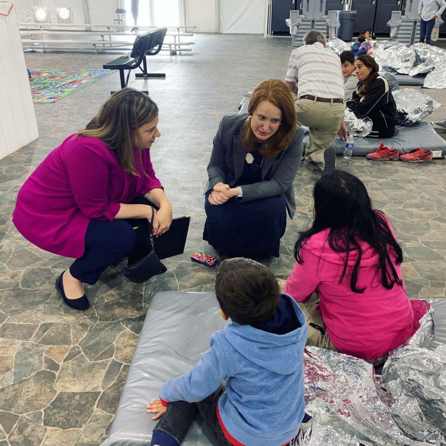 Rep. Elissa Slotkin and her deputy chief of staff Danielle Most talk to two children at a CBP holding facility in Donna, Texas.