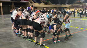 Twin Valleys Roller Derby skaters pass under a bridge made by the Carolina Bootleggers, a rival team.