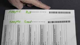 A Clackamas County election worker shows barcodes on ballots that are bad (top) and good on May 19 in Oregon City, Ore. Ballots with blurry barcodes that can't be read by vote-counting machines are delaying results in a key U.S. House race.