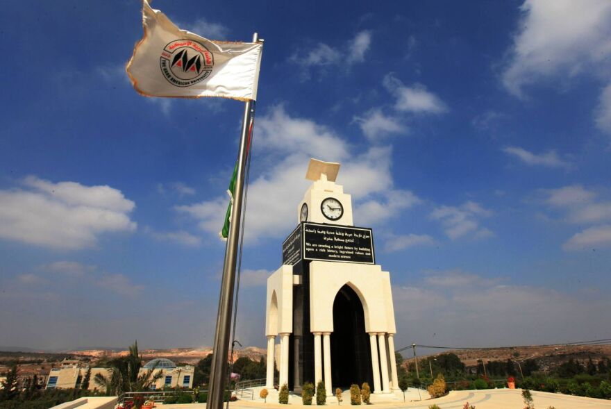 A white building with a flag next to it.