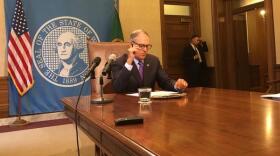 Washington Gov. Jay Inslee prepares to act on a business and occupation tax at the Washington capitol. AUSTIN JENKINS / NORTHWEST NEWS NETWORK
