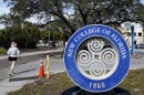 A student makes her way past the sign at New College of Florida, Jan. 20, 2023, in Sarasota, Fla. Attorneys for New College of Florida, the traditionally progressive public liberal arts college which was taken over by allies of Gov. Ron DeSantis as part of his “war on woke,” last week threatened to sue a group of former faculty members and students. It's because they have formed an alternative online institute named “Alt New College” after departing the school following the takeover.