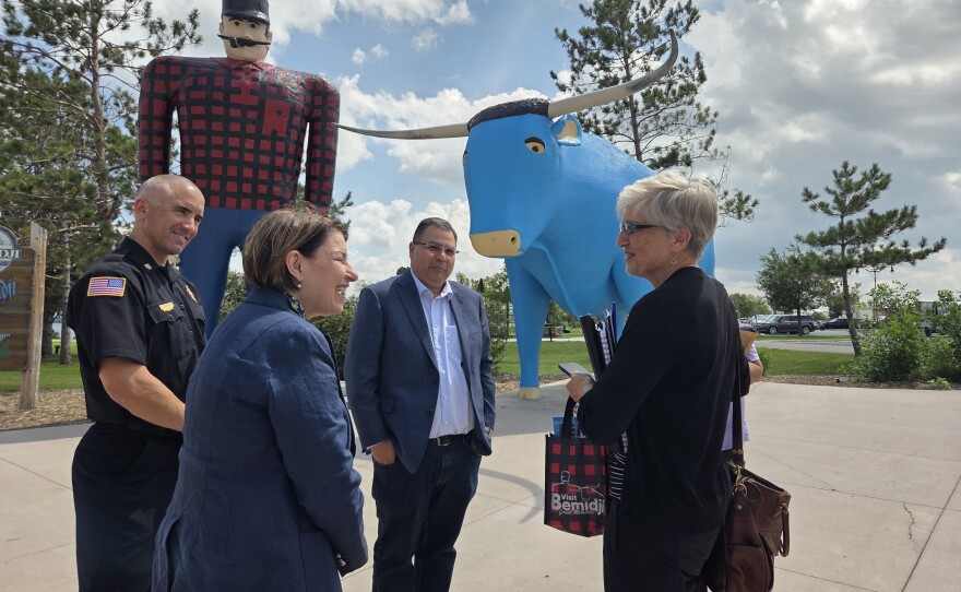 U.S. Sen. Amy Klobuchar, front left, visits with a staffer in front of Paul Bunyan and Babe the Blue Ox with Bemidji Fire Chief Justin Sherwood, back left, and Mayor Jorge Prince, center, on July 25, 2025.