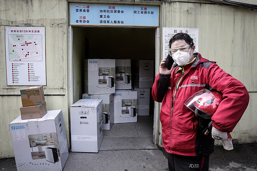 A delivery worker makes a phone call. Usually, couriers deliver packages right to a customer's door, according to Ling Cao, a representative from JD Logistics, one of China's largest delivery companies. But to avoid unnecessary contact, couriers have been calling their customers to let them know their package is ready for pickup — or leaving them in lockers or special pick-up zones.