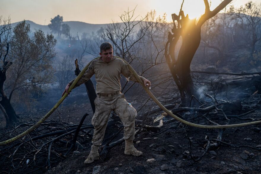 Army soldiers using water hoses try to extinguish forest fires close to the Kemerkoy Thermal Power Plant, at Oren in Milas, northen Turkey on August 4, 2021.