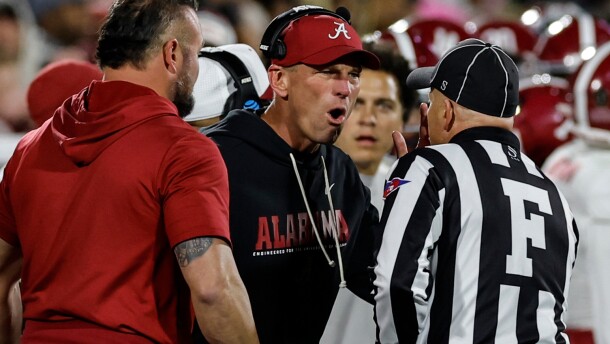 Alabama head coach Kalen Deboer, center, speaks with an official during the first half in the first round of an NCAA College Football Playoff against Oklahoma, Friday, Dec. 19, 2025, in Norman, Okla. (AP Photo/Alonzo Adams)